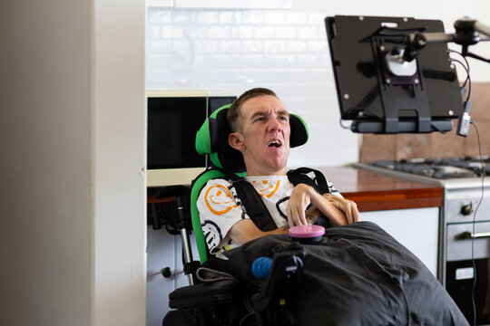Young man with disability on his wheelchair looking on an acc screen