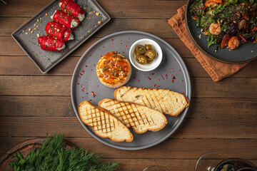 Portion of baked brie with jalapeno pepper and toast on wooden table