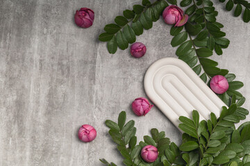 Mockup of greeting card, wedding invitation, congratulations. Lilac rose buds, green branches and plaster mold on concrete background.