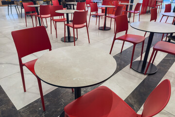 Red chairs and tables in a food court. Selective focus.