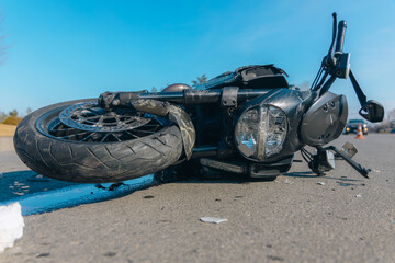 Black motorcycle with serious damage is on the asphalt. Accident close-up. Lost control and fell....