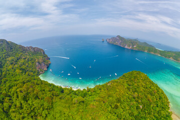 Aerial top view crystal-clear waters gently lap against a sandy beach surrounded by vibrant...