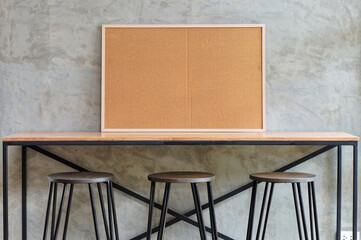 Modern Industrial Workspace with Cork Board and Stools. A contemporary workspace featuring a light...