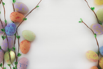 postcard composition of Easter eggs, branches and leaves on a white background with space for text