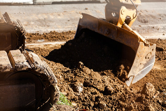 Caterpillar tracks and scoop of digger on construction site
