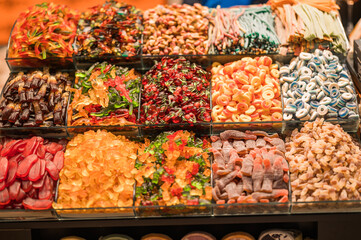 Colorful assortment of gummy and sour candies displayed at a candy shop, showcasing a variety of flavors and textures in a vibrant, sweet-filled market.