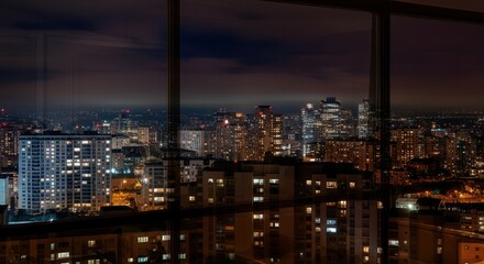 Nighttime urban cityscape with illuminated skyscrapers and high-rise buildings.