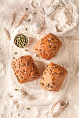 Homemade bread rolls topped with pumpkin seeds, baked to perfection.