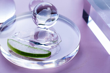 Aloe slices and serum droplets arranged on a round glass in a serene spa setting.