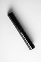 Vertical Mockup of a glossy black cosmetic tube on a clean white background.