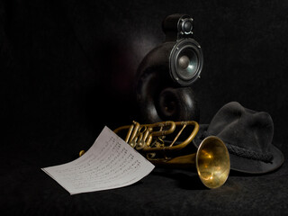 gold trumpet and speaker column on a black background