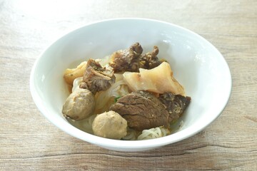 dry boiled thin rice noodles topping slice braised beef meat and tendon with meatball on bowl