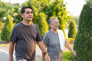 Obraz premium Active seniors walking together in park during sunset, enjoying their time