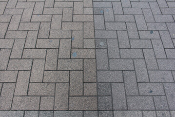 Texture of square paving tile. Pattern of gray and brown sidewalk tiles in the street. Concrete pavers close up background.