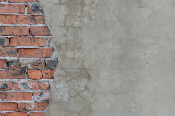 Wall with fallen off cement plaster. Texture old wall with some of gray cement plaster fell off, revealing masonry made of red weathered brick, background whit a lot of copy space, high resolution.