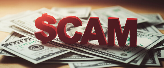 Red letters spelling SCAM on pile of dollar bills, symbolizing financial fraud and deception