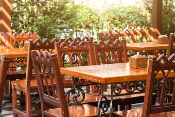 summer sunny patio wooden material furniture empty space without people in restaurant garden outdoor floral decorative aesthetic