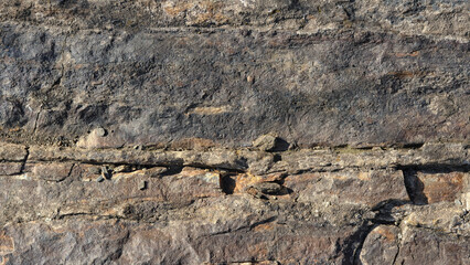 wide format background of stone surface covered with cracks and unevenness