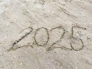 Die Jahreszahl 2025 in den Sand geschrieben am Ufer in den Niederlande