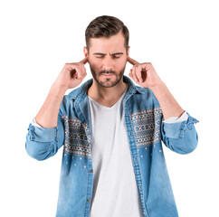 Young man in denim shirt covering ears with fingers, eyes closed, isolated on white background....