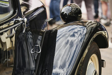 Close up. Detail of an old vintage black car. Shiny hood, wheel