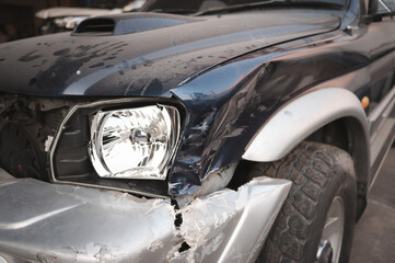 Vehicle Repair Needed. The broken headlight, dented fender, and exposed internal parts suggest the need for professional auto repair services.