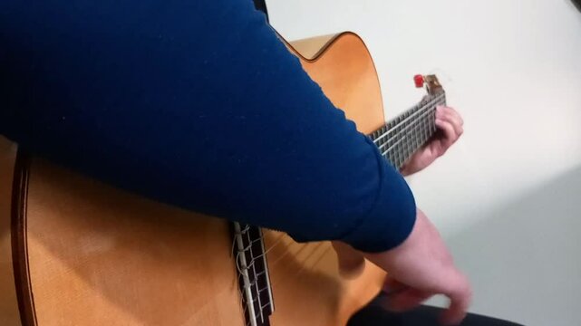 Right angle side from the guitarist right and left hand,strumming guitar with abanico flamenco technique in bulerias piece