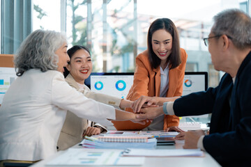 Business people joining hands during a meeting, showing teamwork and collaboration