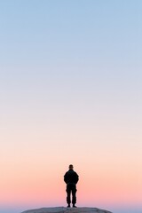 Fototapeta premium silhouette of lone soldier standing at attention against serene clear horizon at sunrise showcasing sense of duty and