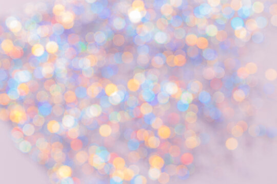 Defocused abstract bokeh background pastel colored, flare from lights, color gradient, blurred circle bokeh as holiday texture. Glittering aesthetic textured lighting pattern