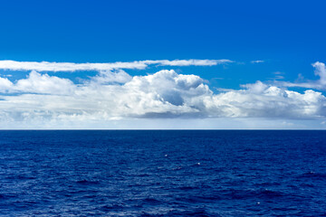 View of the ocean with cumulus clouds and the horizon