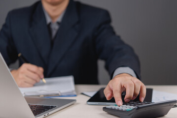 Fototapeta premium businessman working using a calculator and reviewing financial documents. accounting, financial analysis, budget planning, and business tax, finance management, and strategy investment planning.