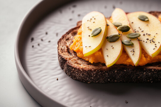 Rye toast with sweet potato puree, apple slices, and pumpkin seeds
