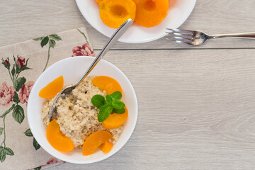 Nutritious milk porridge with pieces of sweet peaches