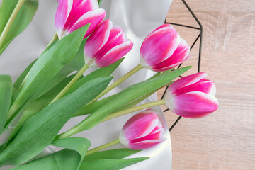 Obraz premium Pink tulips in a basket with pink top view, spring fresh backgorund.