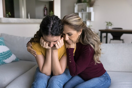 Loving mother embraces her distressed teenage daughter, comforting her after break up or quarrel, offering warmth, comfort, give wise advice, emotional support, showing deep empathy. Parental support
