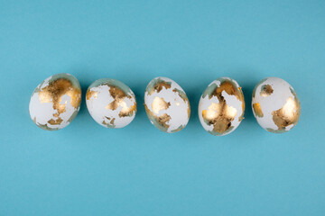 Gold Easter eggs on a pastel blue background. Easter banner, place for a text.