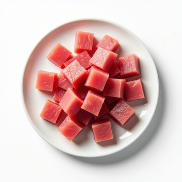 Cubitos de at&uacute;n en un plato blanco.