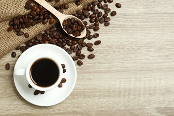 Cup of coffee and coffee beans on wooden background