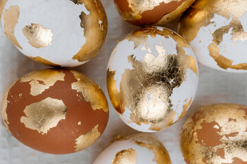Easter golden eggs in a basket on a white background, top view. Easter festive banner.
