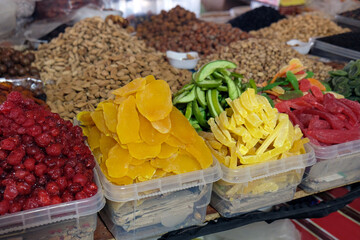 colorful nuts and dried fruits in plastic containers at the market