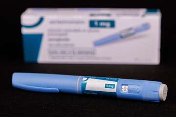 The Ozempic pen and box are featured on a black background, highlighting the semaglutide medication used in diabetes and obesity therapy