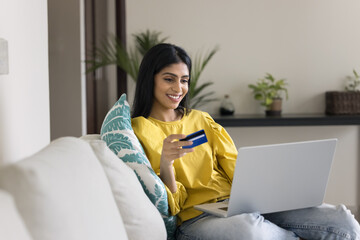 Woman enjoy electronic shopping at home, sit on couch with laptop, holding card, placing online...