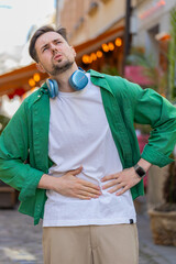 Caucasian young man traveler feeling sudden strong abdominal stomach ache, gastritis problem. Upset...