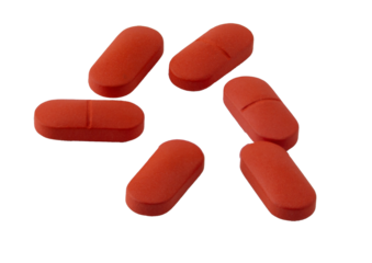 red pills on white background: medication and health
