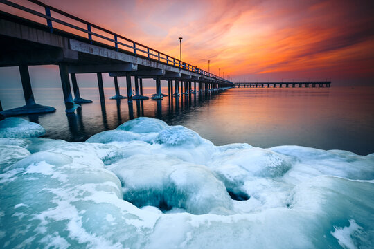 Icy rocks on the beach by Palanga Pier at sunset, Klaipeda, Lithuania