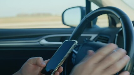 Close-up of driver hands using smartphone while driving car, risk of distraction and road safety concerns. Dangerous driving of vehicle, violation of traffic rules