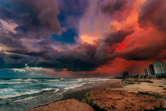 Dramatic sunset over waterfront cityscape and beach, Tel Aviv, Israel