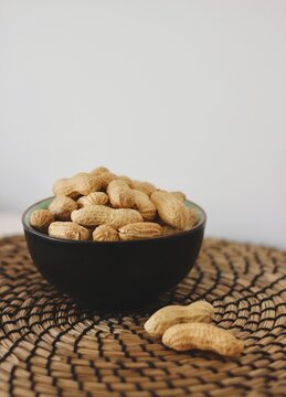 Close-up of a bowl of roasted organic peanuts in their shells