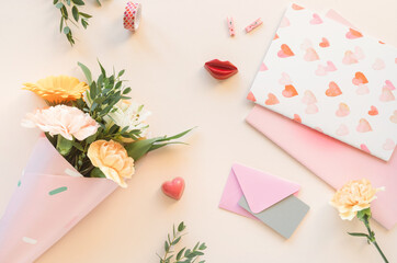 Overhead view of a bunch of flowers, stationery and hearts on a table